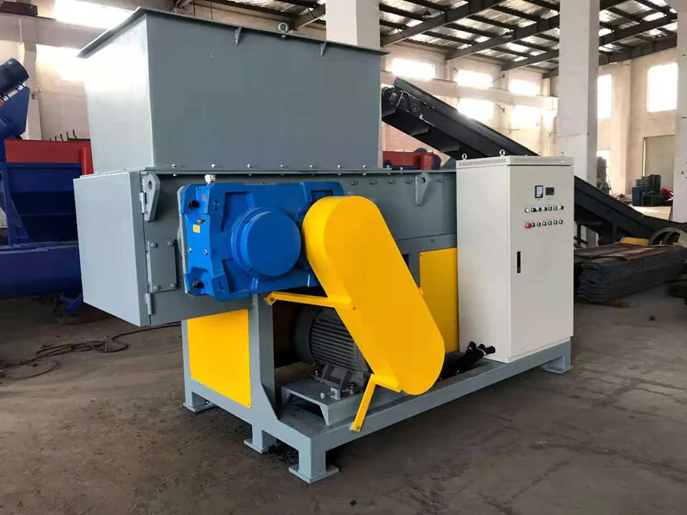 Single shaft plastic shredder with controlled material feeding